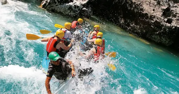 Un gruppo si diverte con il rafting nelle Marche, pagaiando tra spruzzi d'acqua cristallina e rocce imponenti. Un'avventura emozionante!