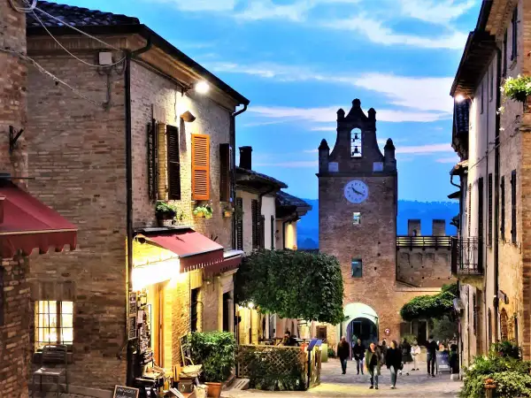 Serata magica a Gradara, Marche. Vicoli illuminati, torre dell'orologio e un'atmosfera incantevole.